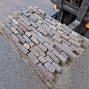 Circulaire ouderwetse gebakken 5-duimers waaltjes in rood genuanceerde kleur, hergebruikt voor duurzame tuinbestrating.