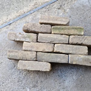 Stapel authentieke 2e-hands geel-rode IJsselsteentjes voor tuinbestrating van Rubens Tuinen
